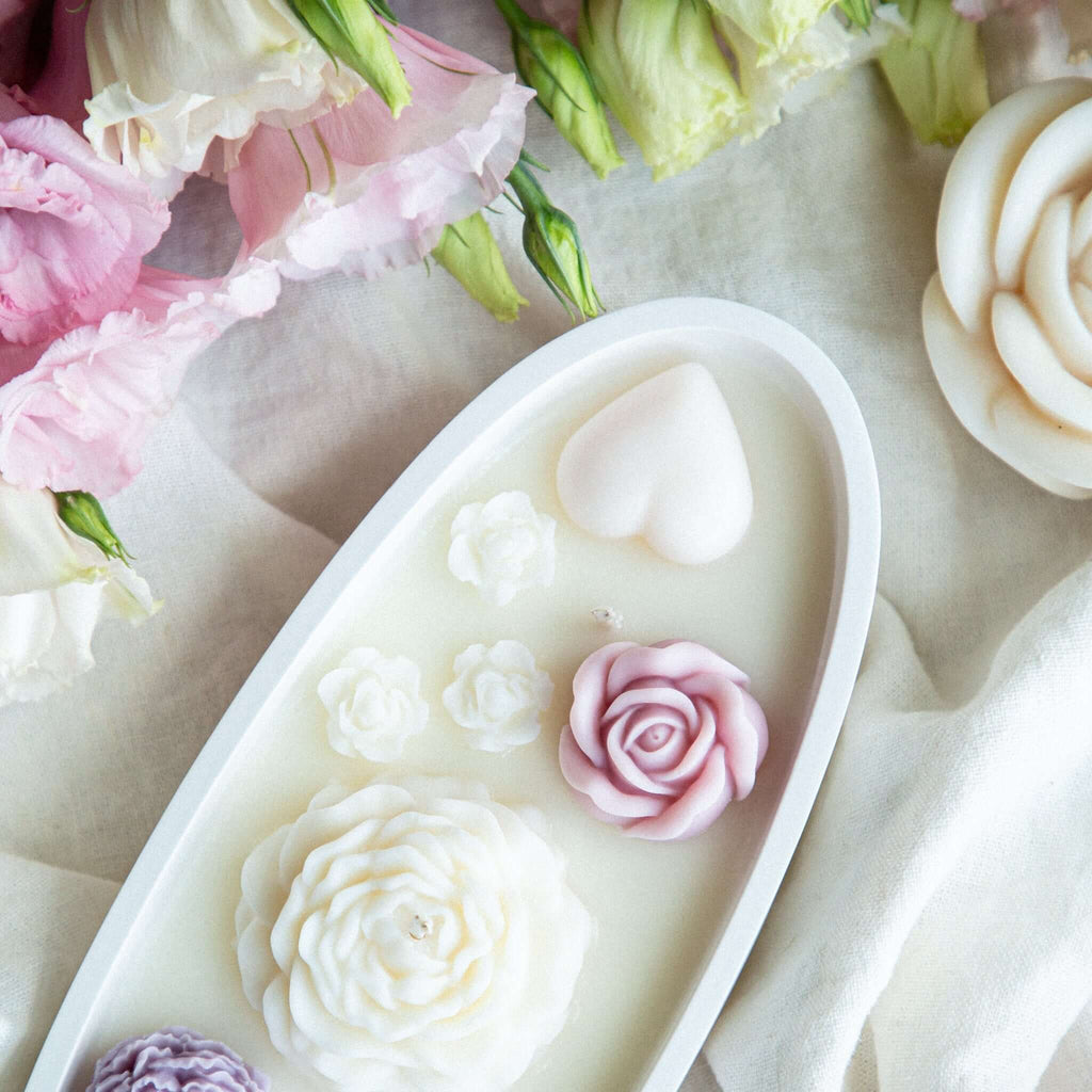 Close-up of artisan soy wax flower candle with roses and heart motifs