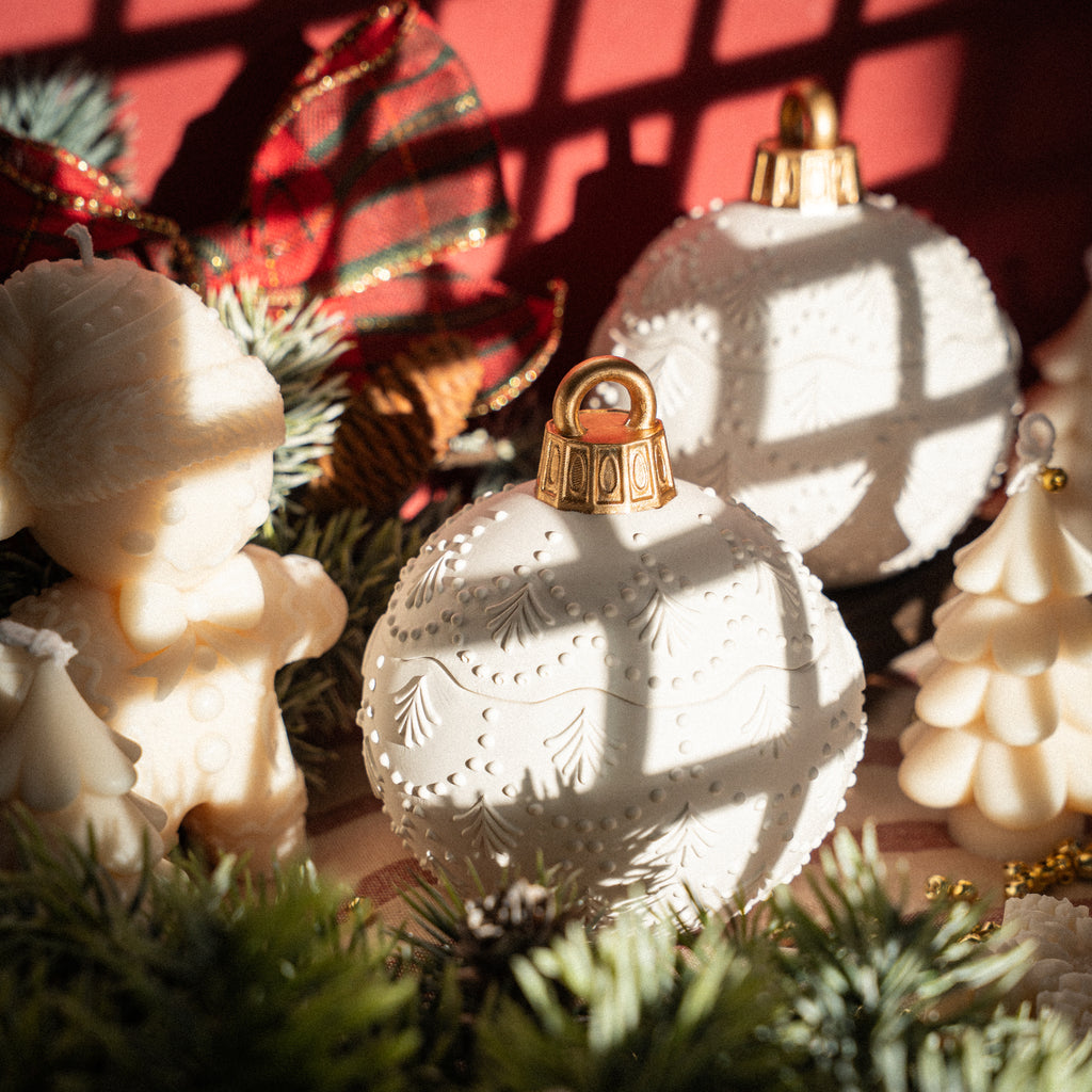 White holiday candle in decorative jar, set with Christmas table decor and greenery