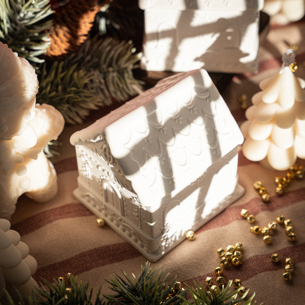 Festive gingerbread house candle crafted in white gypsum for holiday decorations