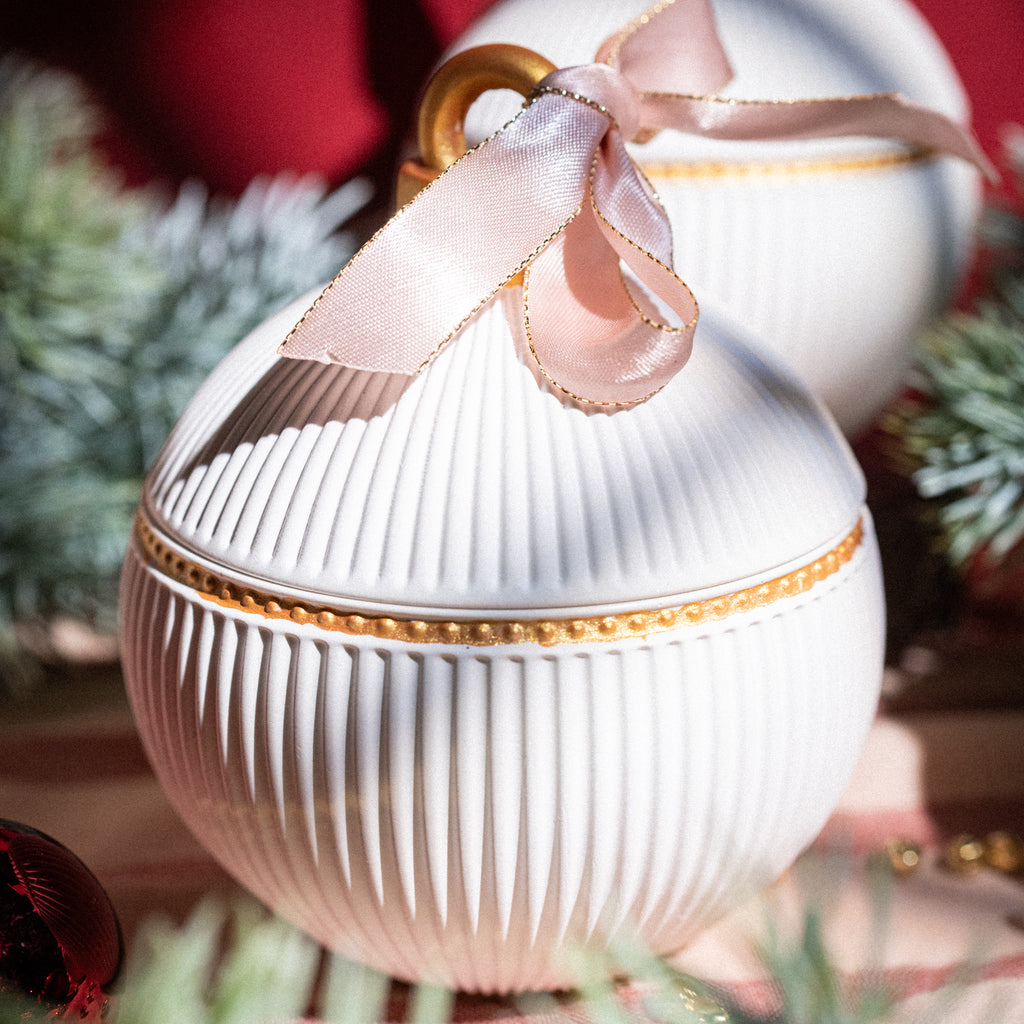 White festive candle with pink bow, ideal for table decoration